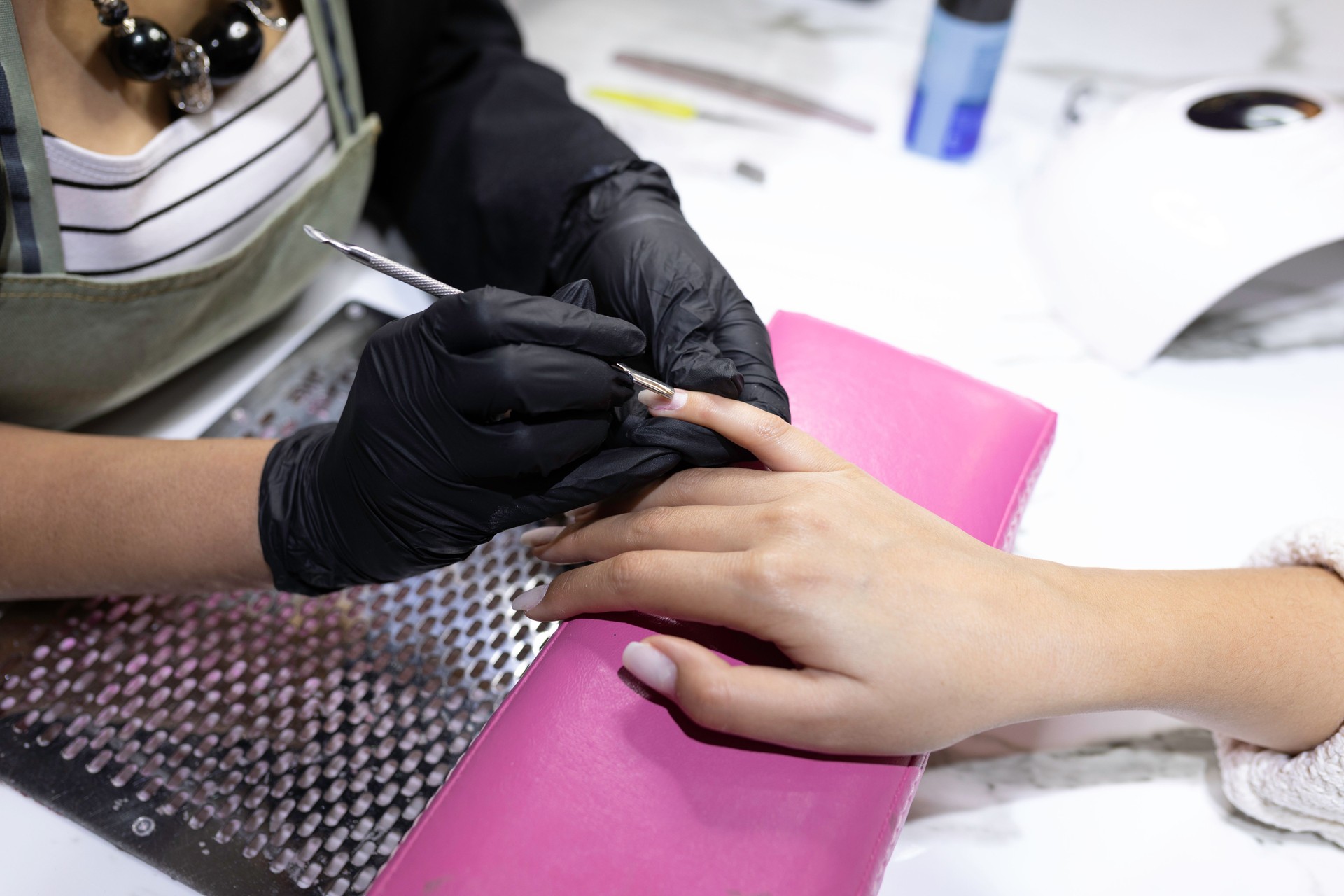 A woman is getting her nails done by a manicurist